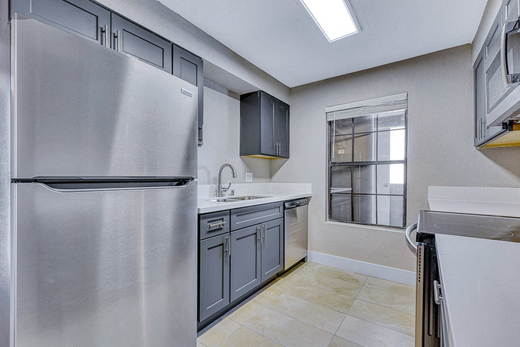 a renovated kitchen with stainless steel appliances and a window