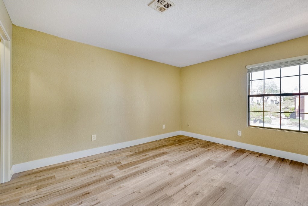 an empty attic with a wooden floor and a window