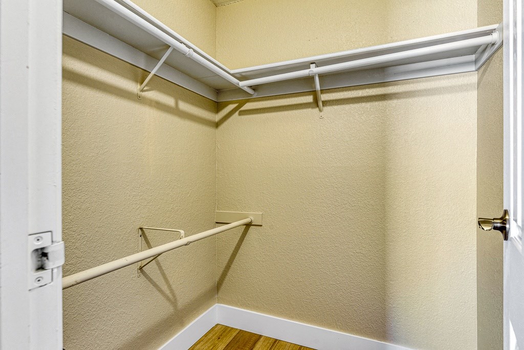 a walk in closet with white walls and a white door