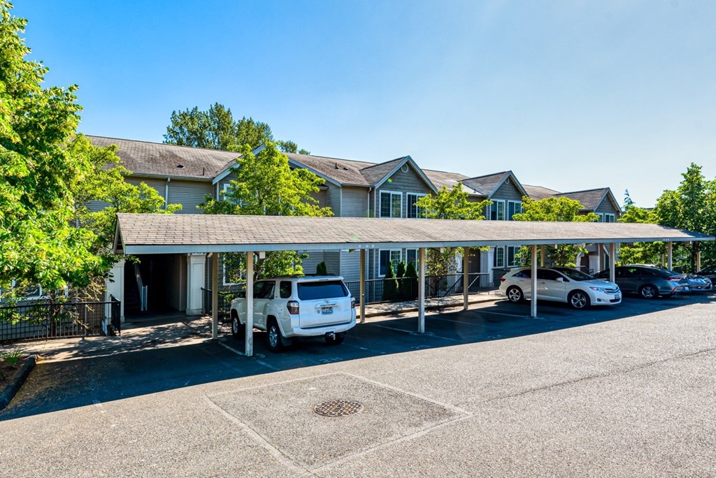 a building with a parking lot with cars in front of it