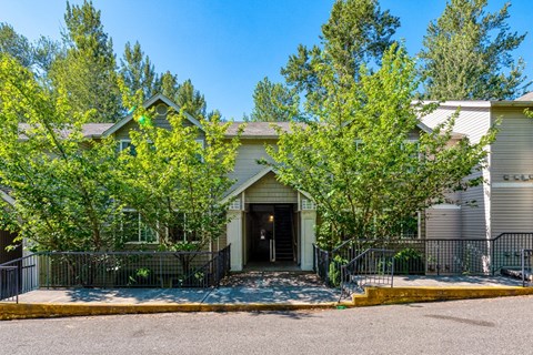 the front of a house with a driveway and trees