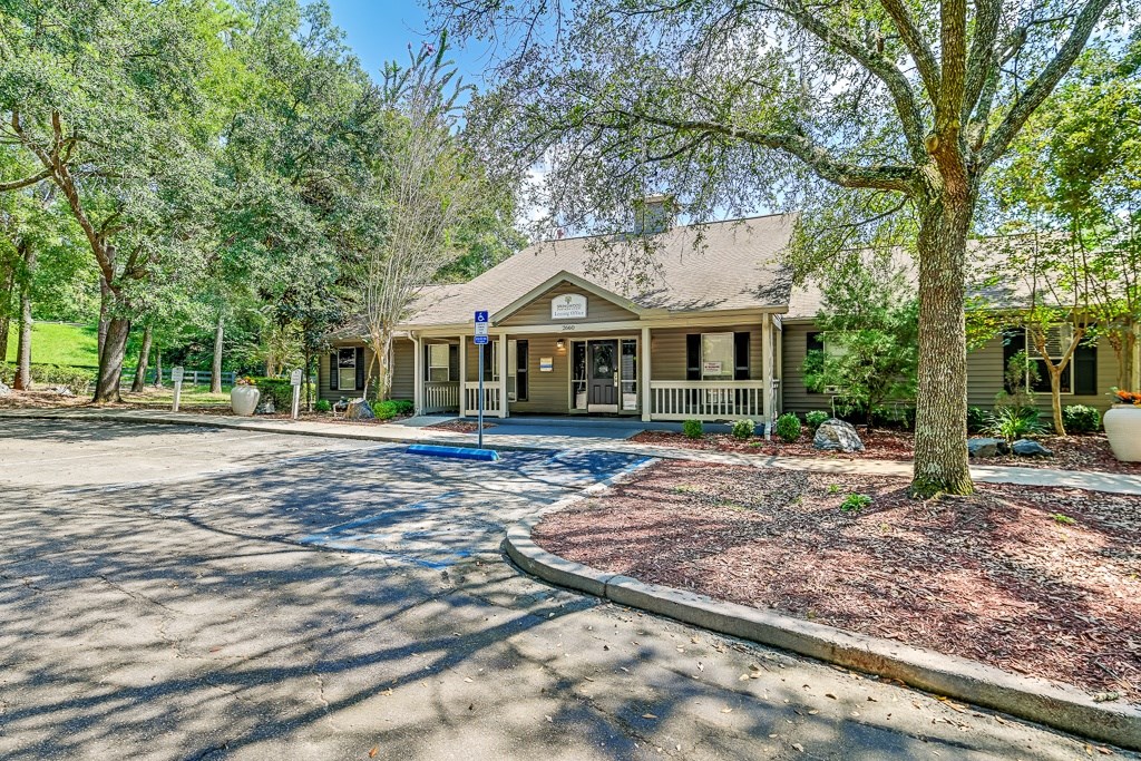 A house with a driveway and trees in front.