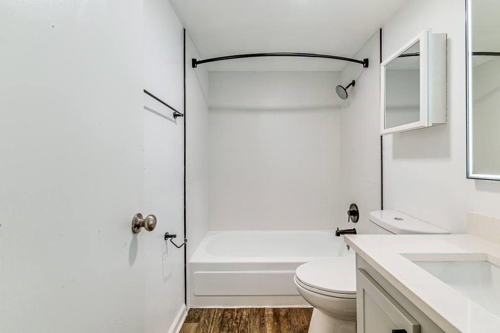 A white bathroom with a toilet, sink, and bathtub.
