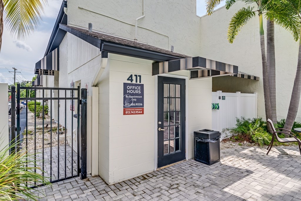 The image shows a building with a sign that reads "411 OFFICE HOURS" and a black gate in front of it.