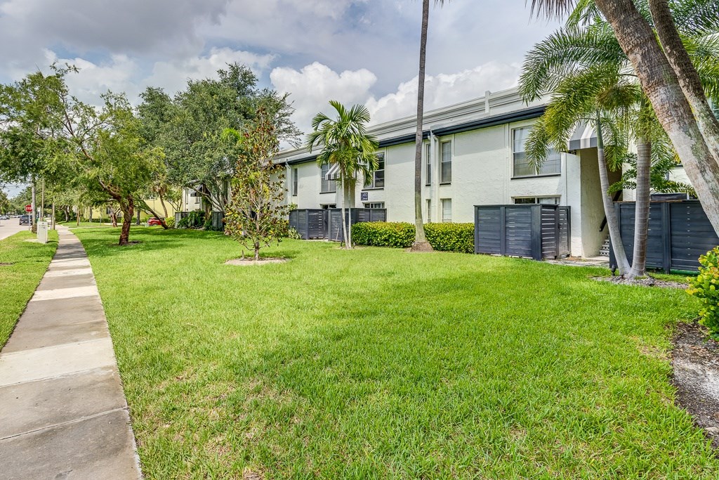 A residential area with a sidewalk and green grass.