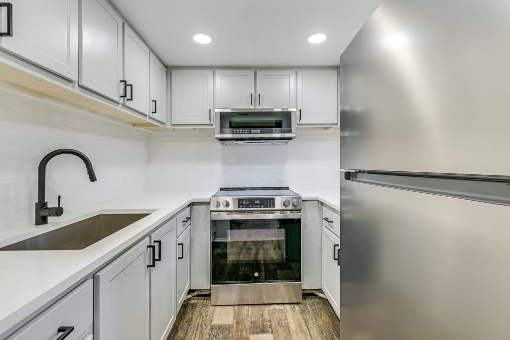 A modern kitchen with stainless steel appliances and white cabinets.