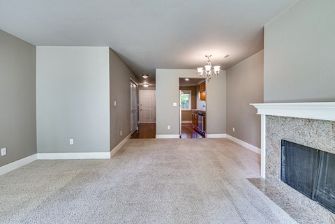a living room with a fireplace and a carpeted floor