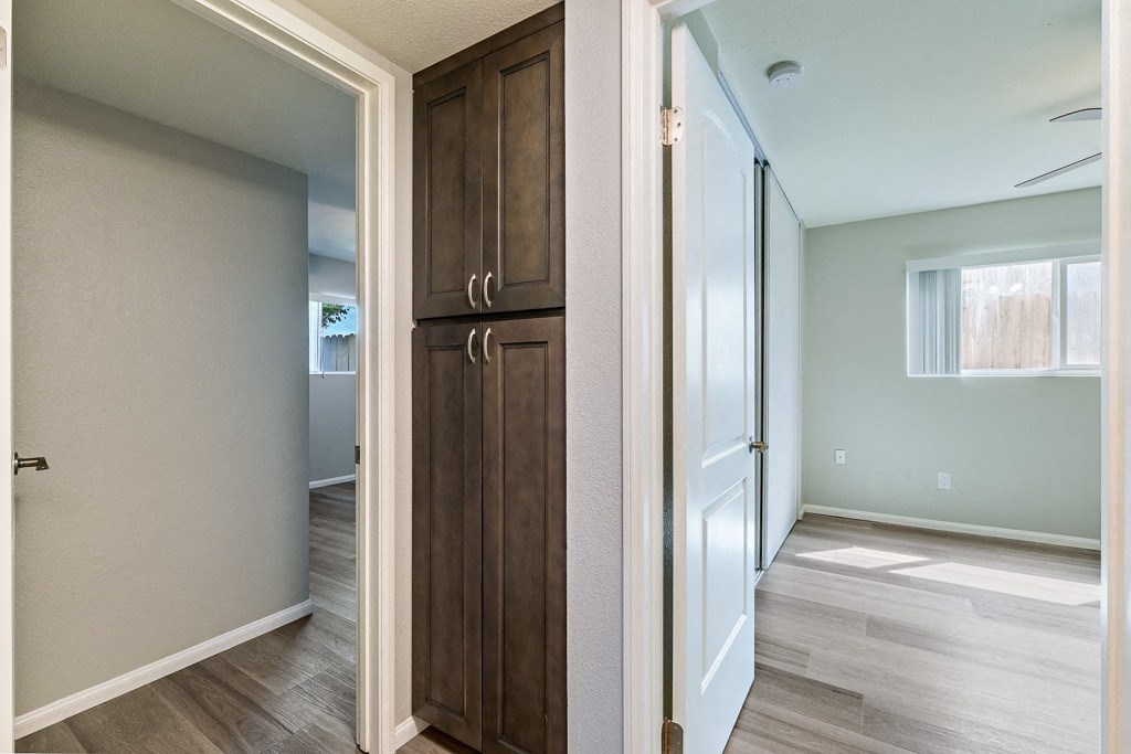 A white door is open to a room with a wooden floor.