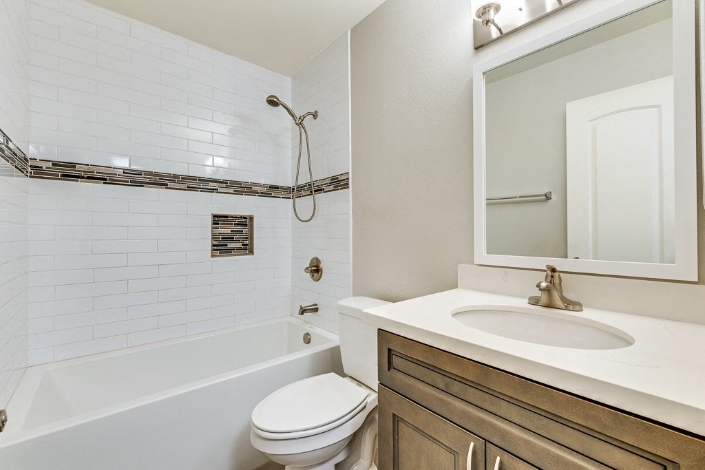 A white bathroom with a toilet, sink, and tub.