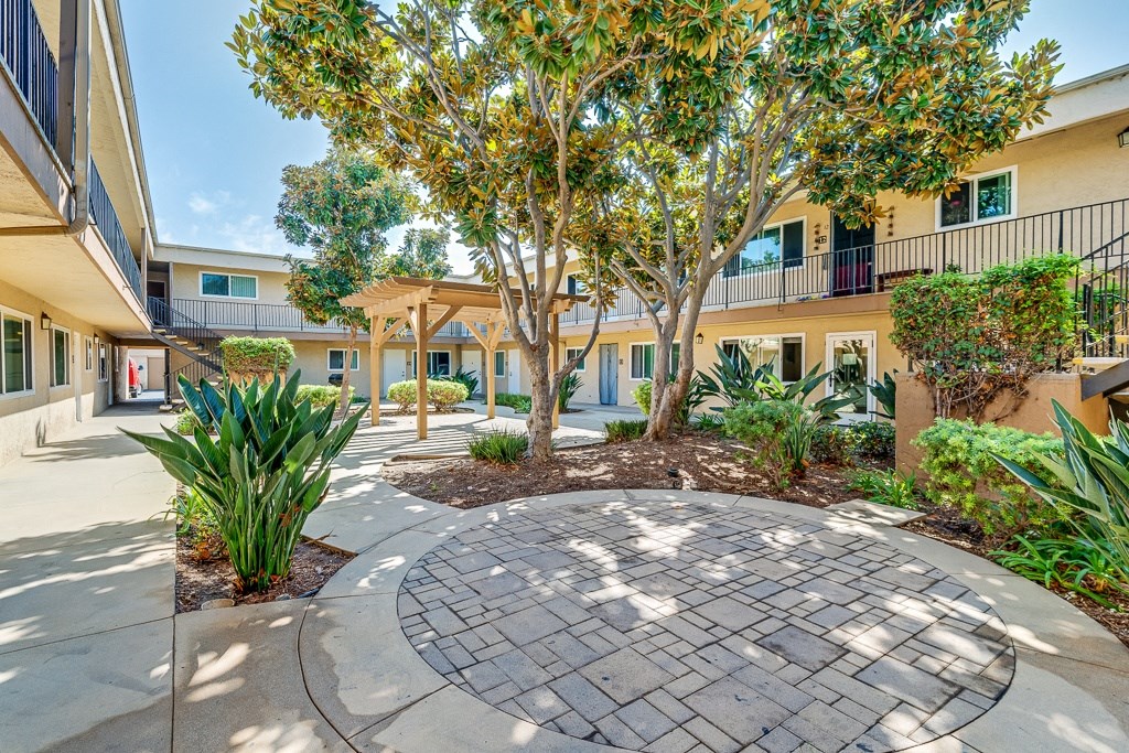 A courtyard with a circular paved area surrounded by trees and plants.