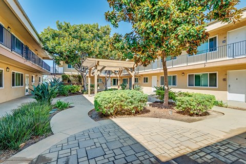 A sunny day at a residential complex with a walkway and trees.