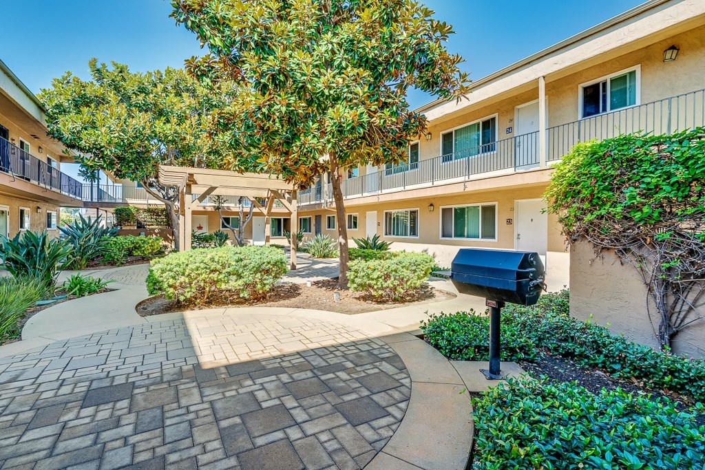 A courtyard with a brick walkway and a mailbox.