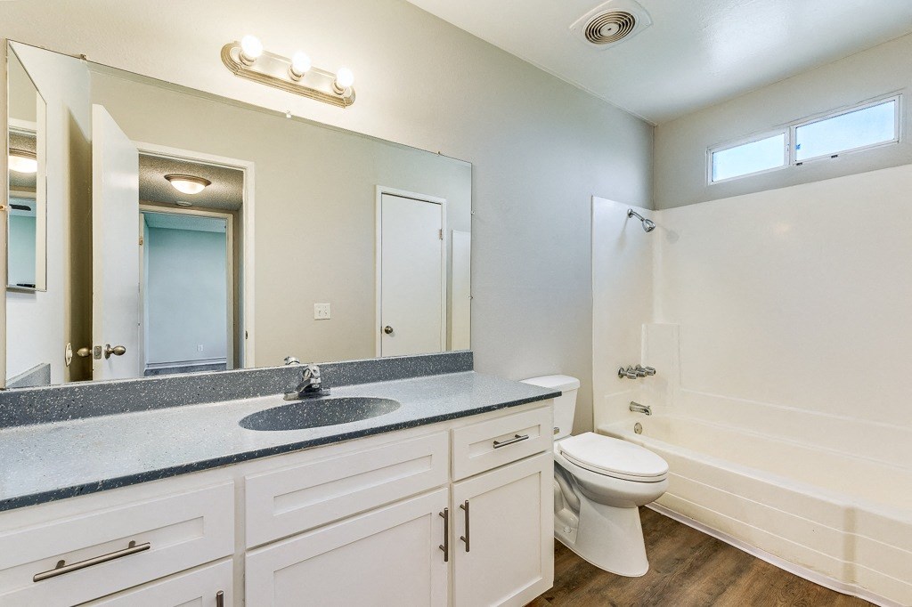 A bathroom with a sink, toilet, and bathtub.