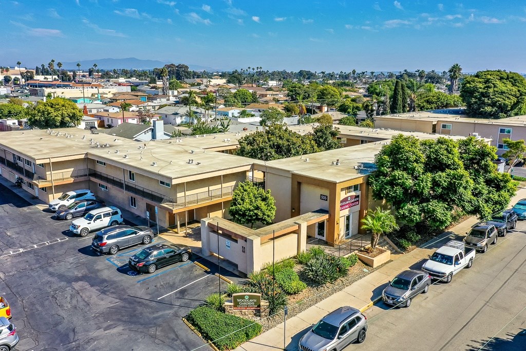 A parking lot with cars and a building in the background.