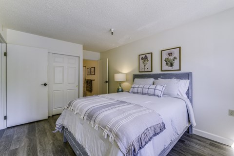 A bedroom with a large bed and a white door.