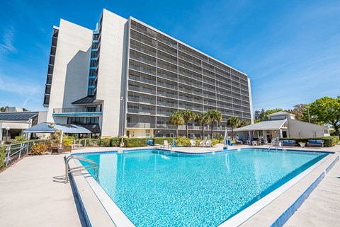 a hotel with a large pool in front of it