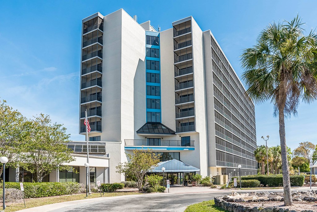 a hotel building with a palm tree in front of it