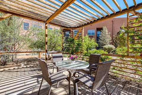 a patio with a table and chairs under a roof