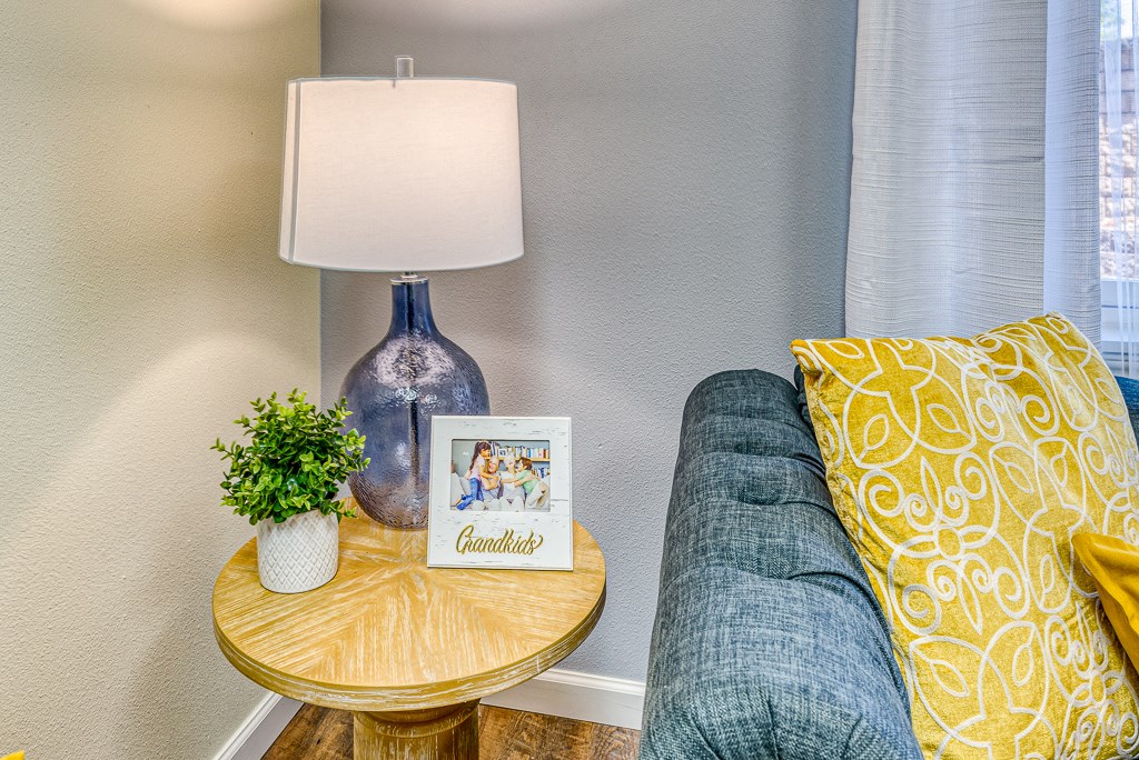 side table with framed photo, plant, and lamp near side of couch