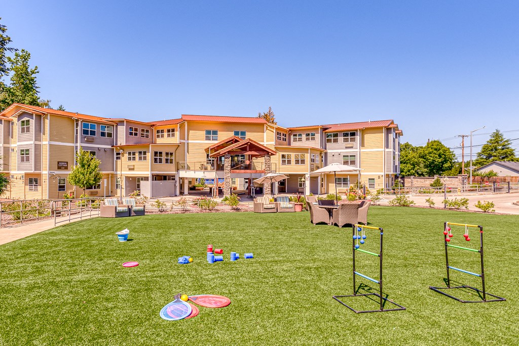 large lawn near community with lawn games and patio seating