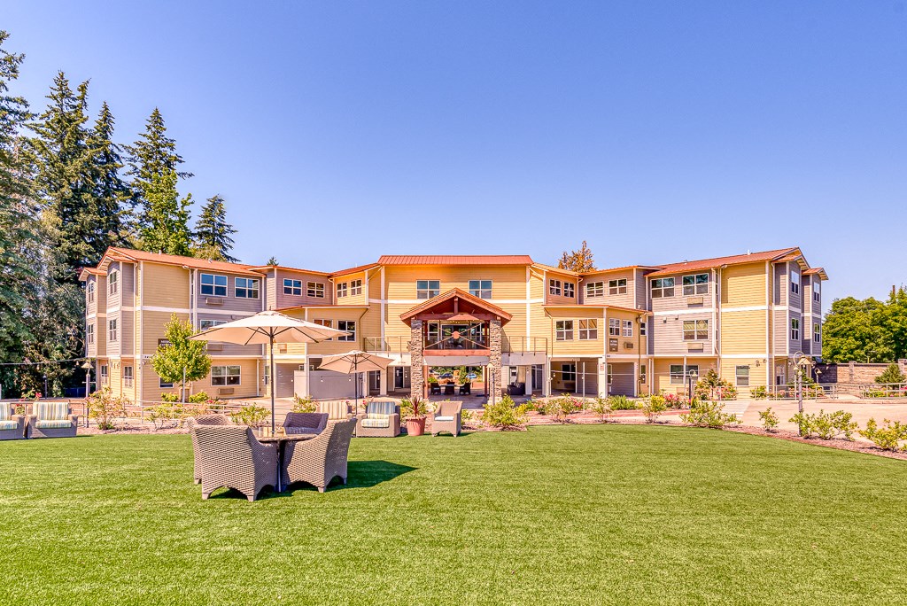 large lawn area near community with patio seating with umbrella