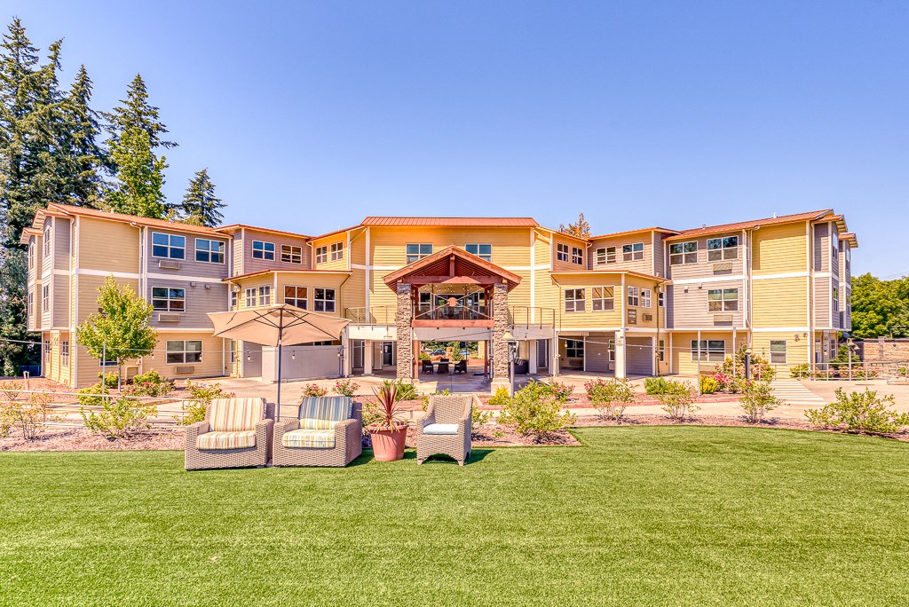 large lawn in front of community with patio seating