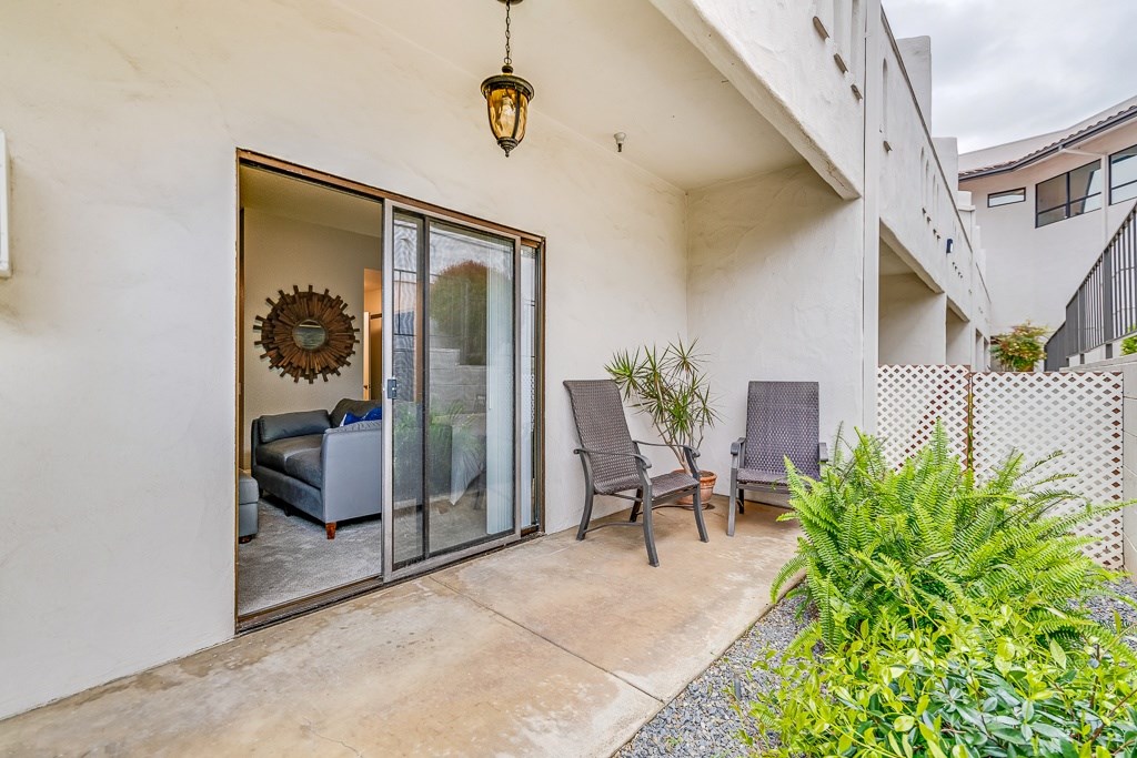 A patio with a chair and a table is visible through a glass door.