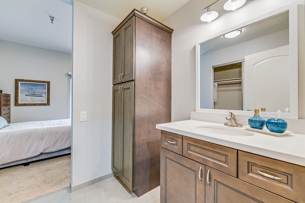A bathroom with a wooden cabinet and a white countertop.