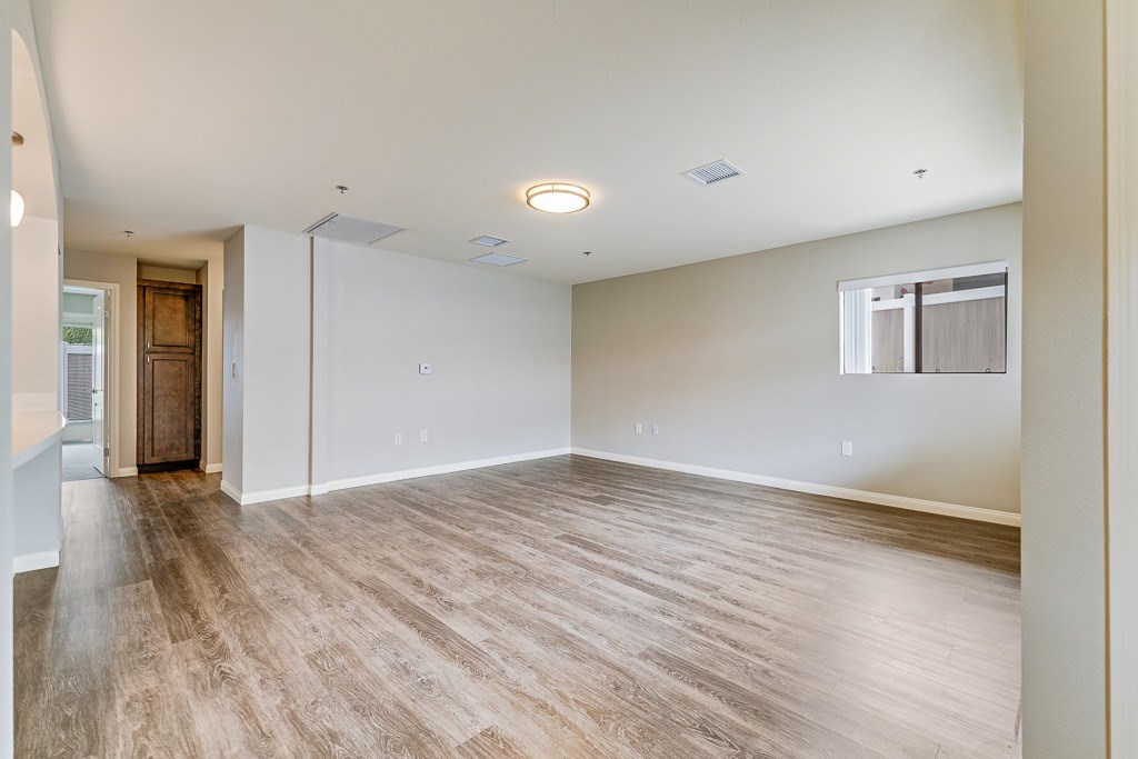 A room with wooden flooring and white walls.