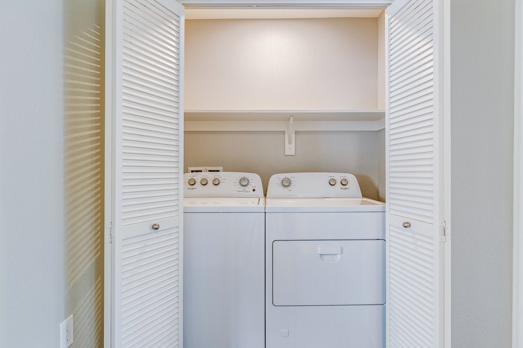 A small laundry room with a washer and dryer.