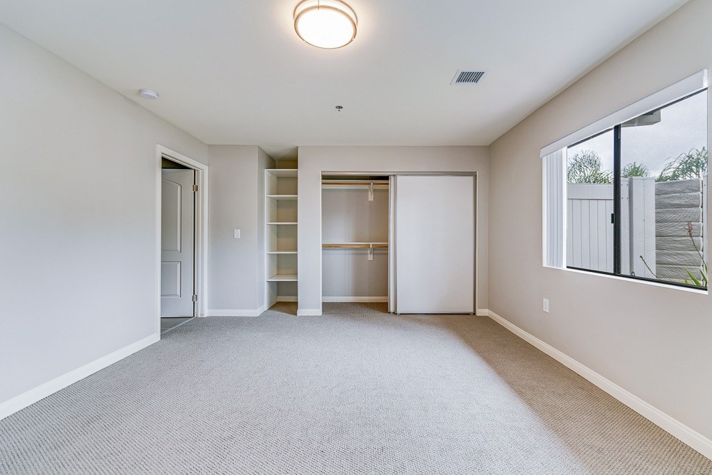A spacious room with a carpeted floor and a ceiling light.