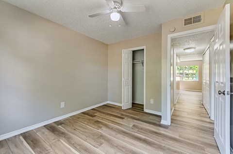 A room with a ceiling fan and wooden flooring. at Green Oaks Apartments, Tampa, Florida