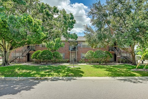 A house with a driveway and trees in front.