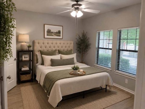 A bedroom with a large bed and a ceiling fan.