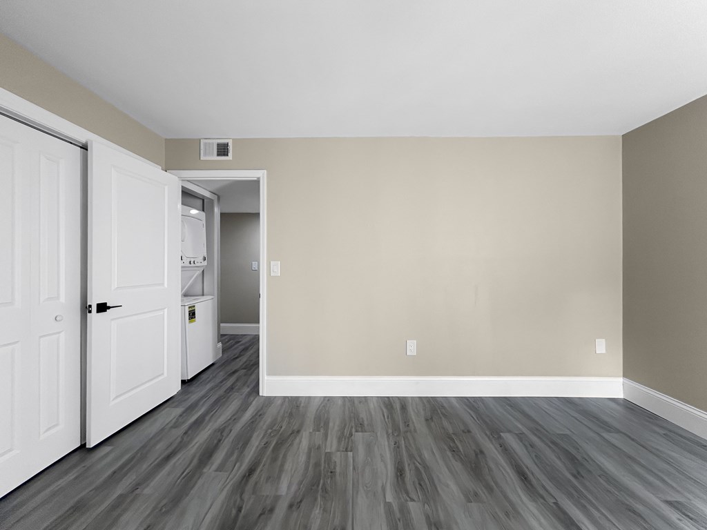 A room with a white door and a grey floor.
