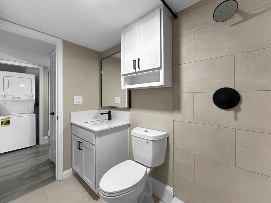 A white toilet sits next to a white sink in a bathroom.