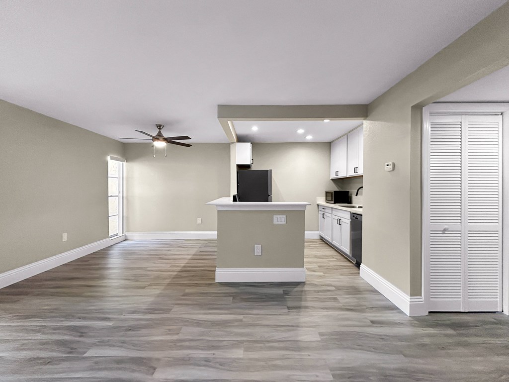 A spacious kitchen with a fan on the ceiling.