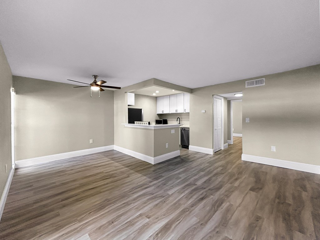 A room with a wood floor and a ceiling fan.