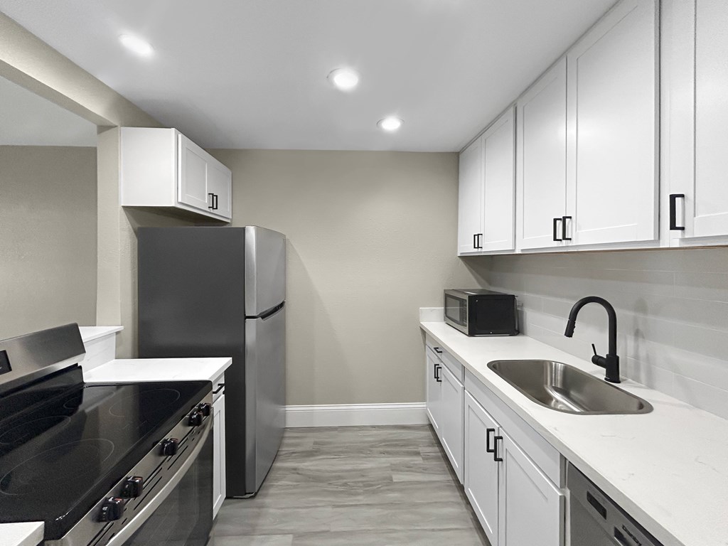 A modern kitchen with a black stove top oven and a black refrigerator.