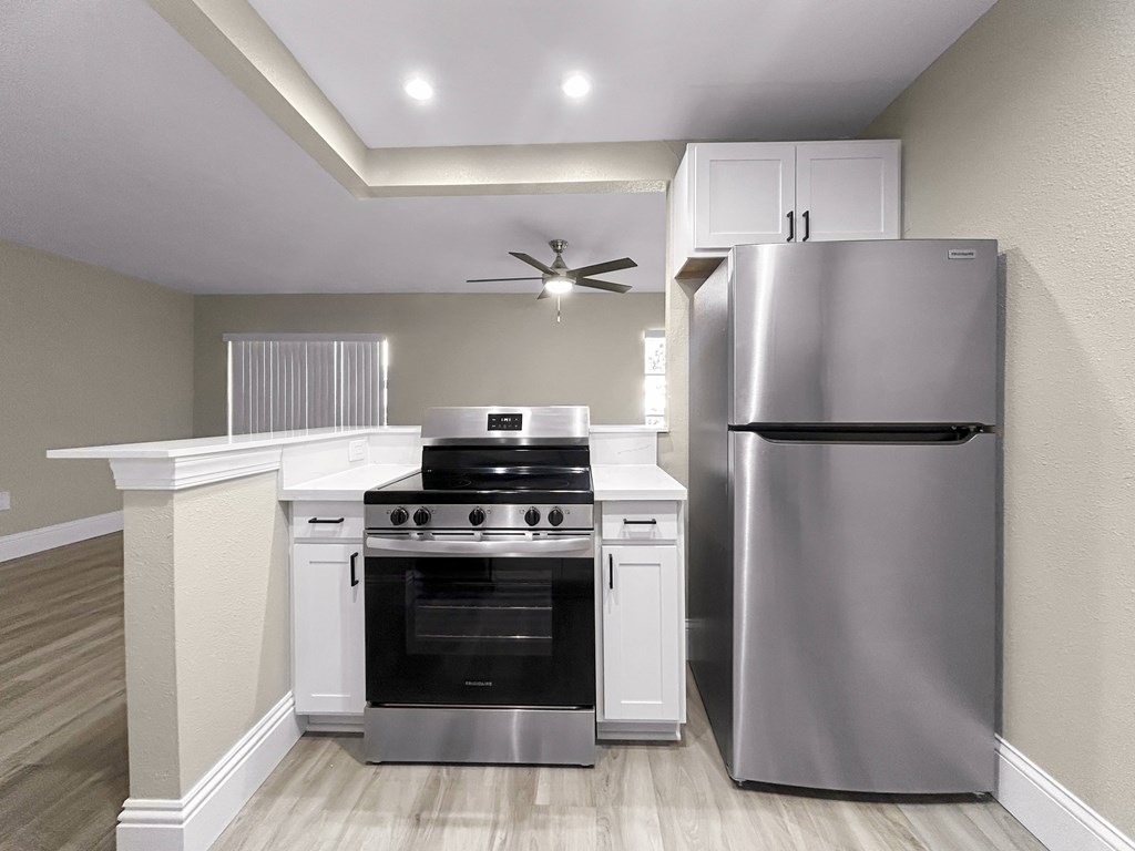 A modern kitchen with a stainless steel refrigerator and a white oven.