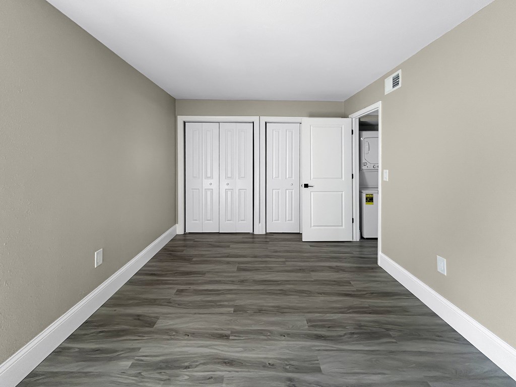 A hallway with a white door and a grey floor.