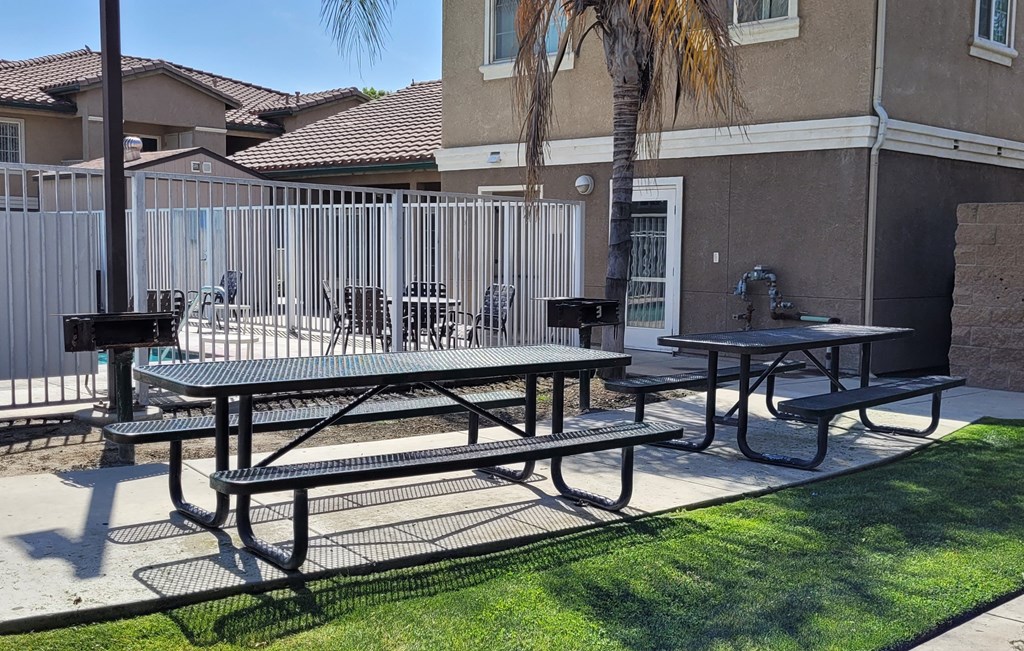 A picnic table is in the middle of a grassy area.