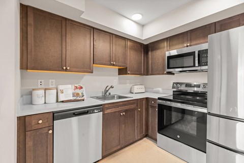A kitchen with brown cabinets and white appliances.
