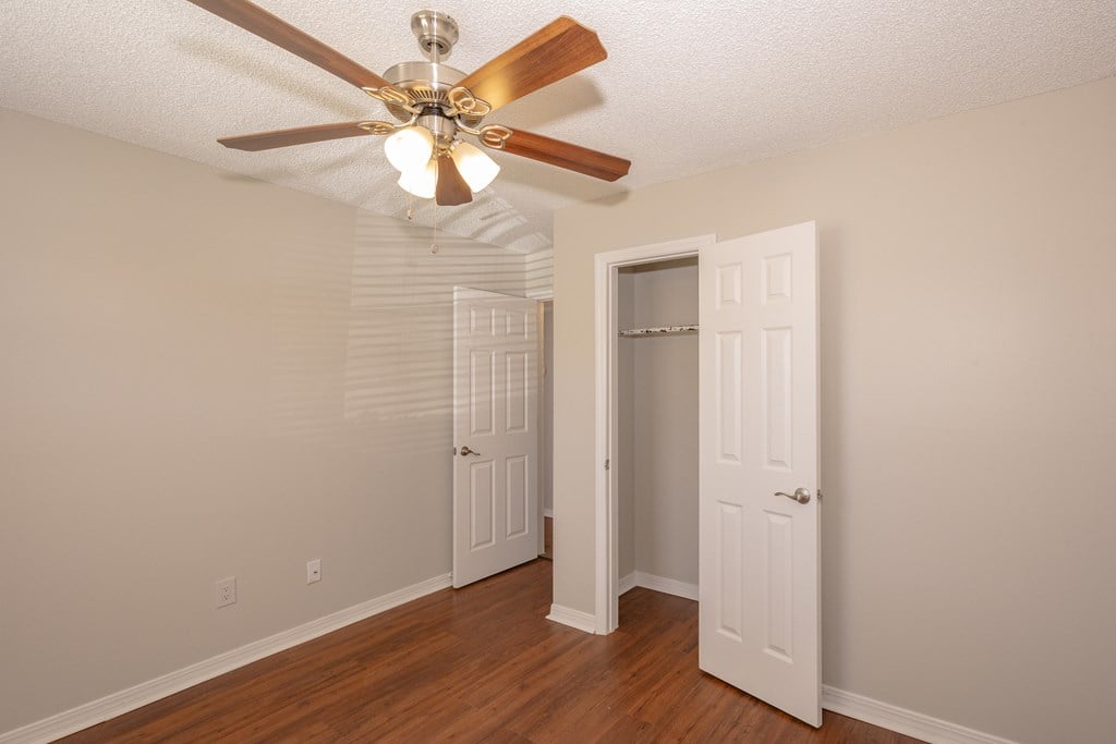 A room with a ceiling fan and two doors.