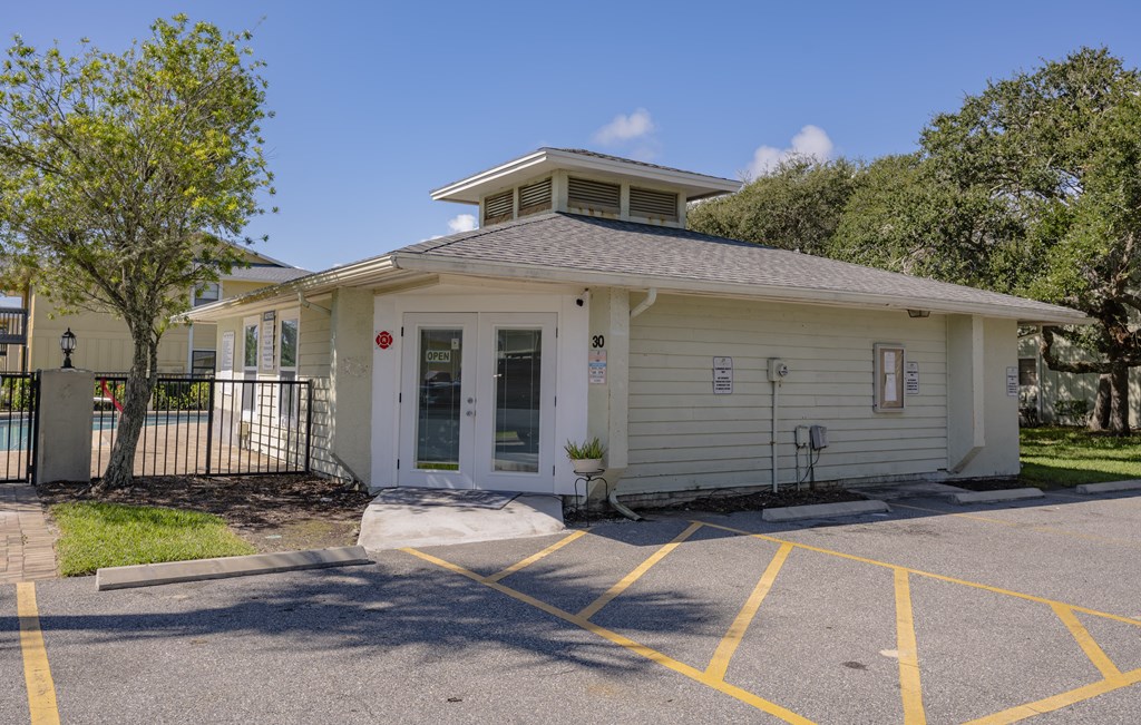 A small white building with a black gate in front.