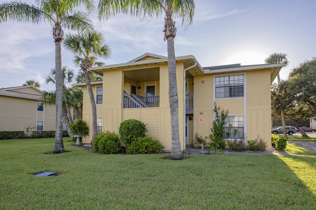 A yellow house with a red stop sign on the door.