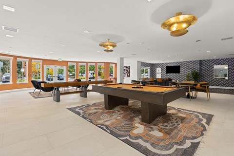 A room with a pool table and a television.