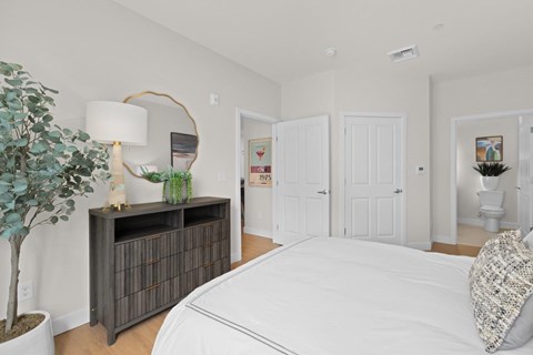 A bedroom with a large bed and a wooden cabinet.