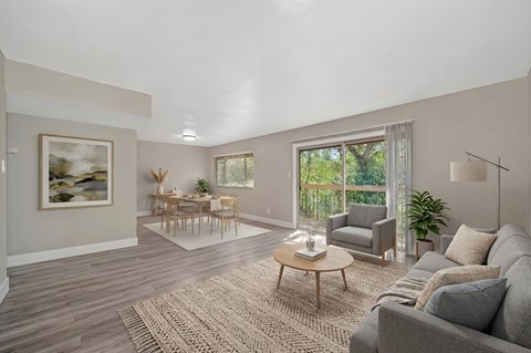 A living room with a grey couch, a wooden coffee table, and a painting on the wall.