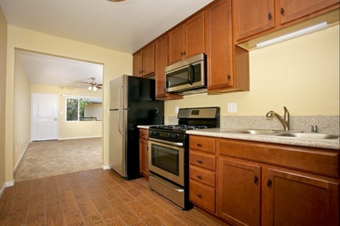 A kitchen with wooden cabinets and a black refrigerator.
